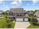 Aerial view of a beautiful home with a three-car garage, manicured lawn, and surrounded by lush greenery at 3679 Woodruff Pl, Bargersville, IN 46106
