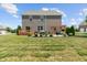 Large backyard featuring a brick home, patio with pergola, landscaped garden, and ample green space at 3679 Woodruff Pl, Bargersville, IN 46106