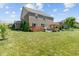 Spacious backyard with a brick home, wooden deck, pergola-covered patio, and mature trees at 3679 Woodruff Pl, Bargersville, IN 46106