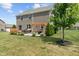 Expansive backyard featuring a brick home, patio with pergola, and lush green lawn at 3679 Woodruff Pl, Bargersville, IN 46106