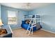 Vibrant blue bedroom featuring a bunk bed, carpet flooring, and ample natural light at 3679 Woodruff Pl, Bargersville, IN 46106