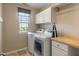 Efficient laundry room with modern washer, dryer, storage cabinets and a wooden countertop at 3679 Woodruff Pl, Bargersville, IN 46106