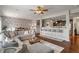 Open concept living room with hardwood floors, view of the dining room and kitchen, a large sectional sofa, and ceiling fan at 3679 Woodruff Pl, Bargersville, IN 46106
