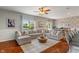 Living room with a large sectional sofa, round coffee table, ceiling fan, and a view of the backyard at 3679 Woodruff Pl, Bargersville, IN 46106