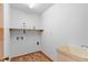 Functional laundry room with utility sink, shelving, and convenient hookups at 370 Vinewood S Dr, Brownsburg, IN 46112