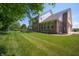 Expansive backyard with lush green lawn and mature trees and view of the patio and brick home at 3853 Abney Highland Dr, Zionsville, IN 46077