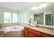 The bright bathroom features a soaking tub and granite countertop, perfect for relaxation and style at 3853 Abney Highland Dr, Zionsville, IN 46077