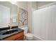 Clean bathroom with a modern vanity, dark countertop, framed art, and shower-tub combo at 3853 Abney Highland Dr, Zionsville, IN 46077