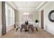 Dining room with glass top table, neutral chairs, chandelier, and decorative accents at 3853 Abney Highland Dr, Zionsville, IN 46077
