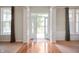 Bright foyer with hardwood floors, white trim, and a view of the front yard through glass doors at 3853 Abney Highland Dr, Zionsville, IN 46077