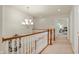 Upstairs hallway featuring a chandelier, railing and a view to a nearby bedroom at 3853 Abney Highland Dr, Zionsville, IN 46077