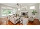 Bright living room featuring a stone fireplace, large windows, ceiling fan, and comfortable seating area at 3853 Abney Highland Dr, Zionsville, IN 46077