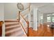 Elegant staircase with carpeted steps, white railings, and views into the living spaces at 3853 Abney Highland Dr, Zionsville, IN 46077