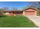 Charming single-story home with well-kept front lawn and a inviting orange front door and access ramp at 40 S Restin Rd, Greenwood, IN 46142