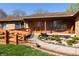 Inviting front porch with orange door, access ramp, seating area and a landscaped walkway in front of home at 40 S Restin Rd, Greenwood, IN 46142
