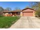 Charming single-story home with an attached garage, well-kept lawn, and a inviting orange front door at 40 S Restin Rd, Greenwood, IN 46142