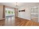 Open dining room with hardwood floors, chandelier, and access to the sunroom at 402 W Clinton St, Danville, IN 46122
