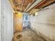 Unfinished basement featuring exposed pipes, a wooden ceiling and an electrical panel at 405 Harlan St, Indianapolis, IN 46201