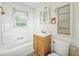 This bathroom offers a vanity, toilet, tub and natural light at 405 Harlan St, Indianapolis, IN 46201