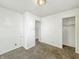 This bedroom features neutral walls, carpeting, and two door leading to an adjacent spaces at 405 Harlan St, Indianapolis, IN 46201