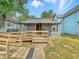 Charming home featuring accessible wooden ramp leading to lattice-covered porch at 405 Harlan St, Indianapolis, IN 46201