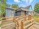 Charming home featuring accessible wooden ramp leading to lattice-covered porch at 405 Harlan St, Indianapolis, IN 46201