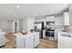 Open kitchen with stainless steel appliances, white cabinets, an island, and hardwood floors at 4182 Hume Ave, Plainfield, IN 46168