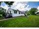 Charming home with a black deck and vinyl siding, surrounded by lush green lawn and mature trees at 4639 Terrace Ave, Indianapolis, IN 46203