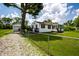 View of the side yard with a gravel driveway, black deck, fenced yard and a detached garage at 4639 Terrace Ave, Indianapolis, IN 46203