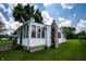 Sunroom, vinyl siding, and a stone chimney with a lush green lawn surrounding the property at 4639 Terrace Ave, Indianapolis, IN 46203