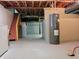 Unfinished basement area with cement floor, water tank, and exposed ceiling at 5052 Helmsburg School Rd, Morgantown, IN 46160