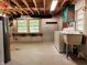Unfinished basement area with utility sink, washer, dryer, exposed beams, and shelving at 5052 Helmsburg School Rd, Morgantown, IN 46160