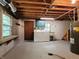 Unfinished basement with laundry area, sink, window, and storage shelving at 5052 Helmsburg School Rd, Morgantown, IN 46160