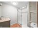 Bathroom features updated walk-in shower, tiled floor, vanity with stone counter, and recessed lighting at 5052 Helmsburg School Rd, Morgantown, IN 46160