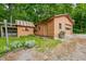 Cozy single-car garage with an adjacent storage shed offers practicality and additional space on a green, treed lot at 5052 Helmsburg School Rd, Morgantown, IN 46160