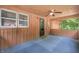 Enclosed porch featuring a ceiling fan, carpeted floor, and windows with wooded view at 5052 Helmsburg School Rd, Morgantown, IN 46160