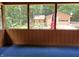 A screened-in porch offers a view of an outdoor area with a garage and patriotic decor at 5052 Helmsburg School Rd, Morgantown, IN 46160