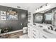 Dark accent wall bathroom features double sink vanity with under cabinet storage and modern fixtures at 5299 Breakers Way, Carmel, IN 46033
