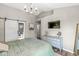 Open bedroom features a mounted television, a stylish chandelier, and an ensuite bathroom with barn door at 5299 Breakers Way, Carmel, IN 46033