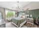 Vaulted ceiling bedroom showcases natural light from a large window, accent wall, and a decorative chandelier at 5299 Breakers Way, Carmel, IN 46033