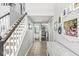 Inviting hallway with staircase, neutral tones, tile flooring and decorative wall art leading into the living spaces at 5299 Breakers Way, Carmel, IN 46033
