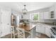 Bright kitchen with stainless steel appliances, white cabinets, and a large island with chairs at 5299 Breakers Way, Carmel, IN 46033