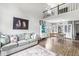 Spacious living room with hardwood floors, a gray sofa, and a unique loft area overlooking the room at 5299 Breakers Way, Carmel, IN 46033