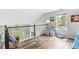 Loft area with wood floors, black handrail, window with backyard view, and desk area at 5299 Breakers Way, Carmel, IN 46033