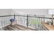 Open loft area with wood floors, black handrail, and scenic view through large windows at 5299 Breakers Way, Carmel, IN 46033