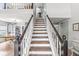 Elegant staircase with dark wood treads and white risers and balusters leading to a second floor living space at 5299 Breakers Way, Carmel, IN 46033
