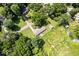 Aerial view displays the property's spacious layout with ample greenery, a shed, and its position within a tree-lined neighborhood at 5672 W New York St, Indianapolis, IN 46224