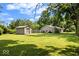 A large grassy backyard featuring a shed and residence, providing an expansive outdoor area for recreation and relaxation at 5672 W New York St, Indianapolis, IN 46224