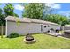 Backyard with a stone fire pit, a lush green lawn, and a patio, ideal for outdoor entertaining and relaxation at 5672 W New York St, Indianapolis, IN 46224