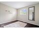 Bright bedroom with warm neutral walls, a large window, sleek wood floors, and a full length mirror on the wall at 5672 W New York St, Indianapolis, IN 46224